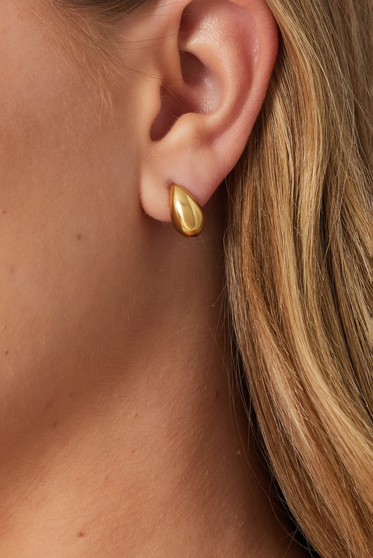 Traanvormige oorbellen goud gestyled aan het oor