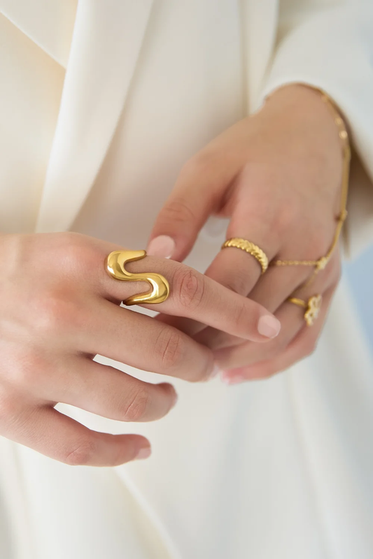 Wavy statementring goud gestyled aan de hand